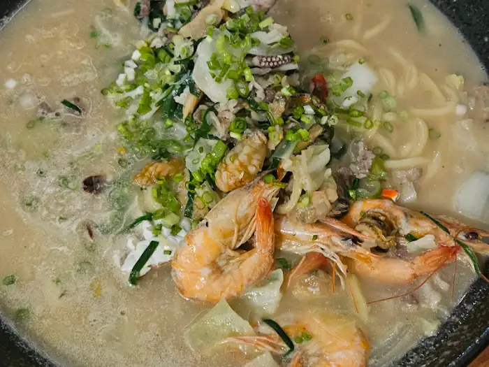 다양한 해산물과 채소가 푸짐하게 담긴 짬뽕의 윗부분이 클로즈업되어 있습니다. 새우, 오징어, 조개 등이 보이며, 파와 배추 등의 채소도 넉넉하게 들어있습니다.