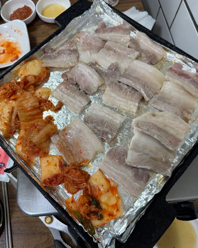 구워지는 냉동 삼겹살과 김치