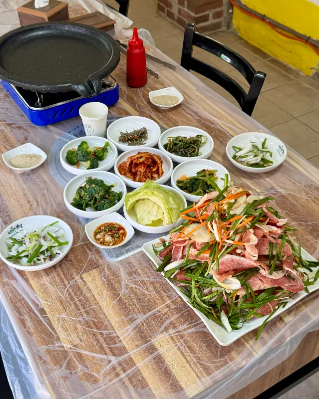 푸짐한 오리불고기와 다채로운 밑반찬이 가득 차려진 테이블