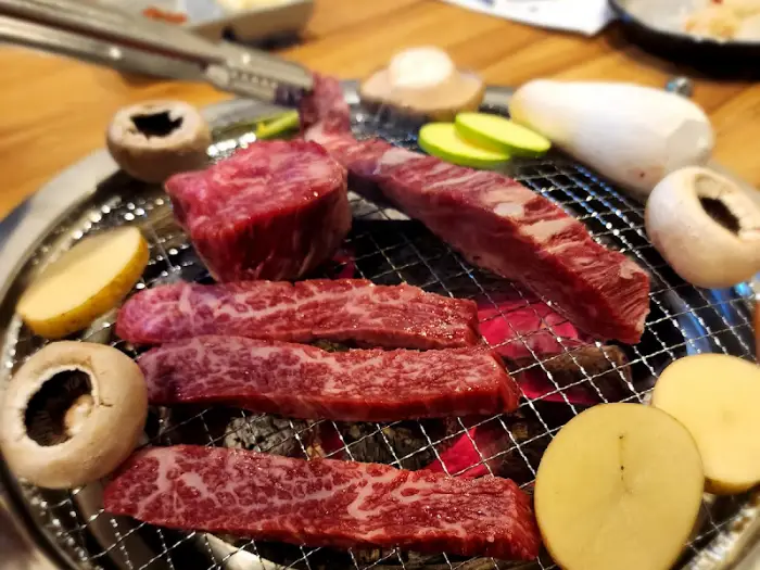 숯불 위에 올라간 두툼한 한우와 버섯, 채소