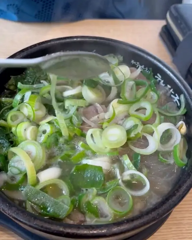 숟가락으로 해장국 내용물을 뜨는 모습