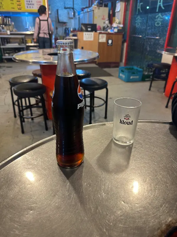 테이블 위에 놓인 음료수 병과 컵