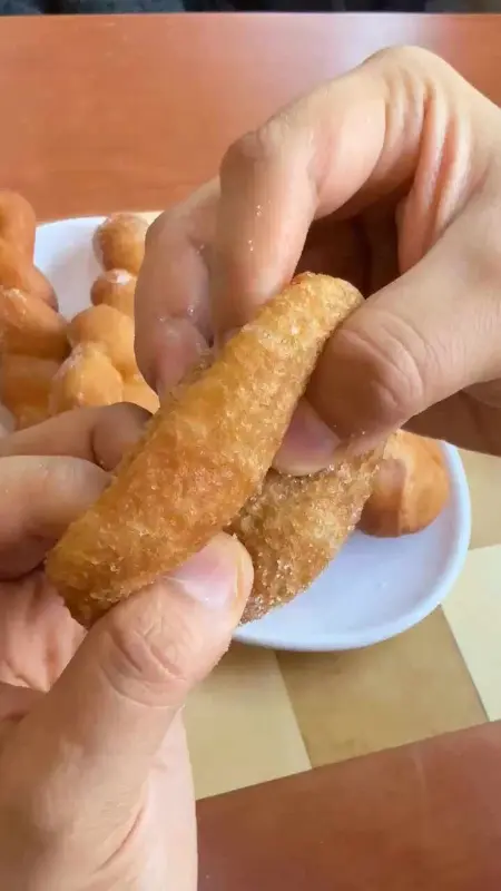 꽈배기를 손으로 찢어 단면을 보여주는 모습