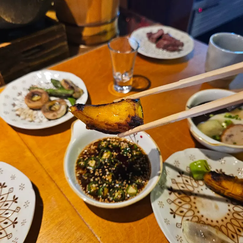 구운 호박을 소스에 찍어 먹는 모습