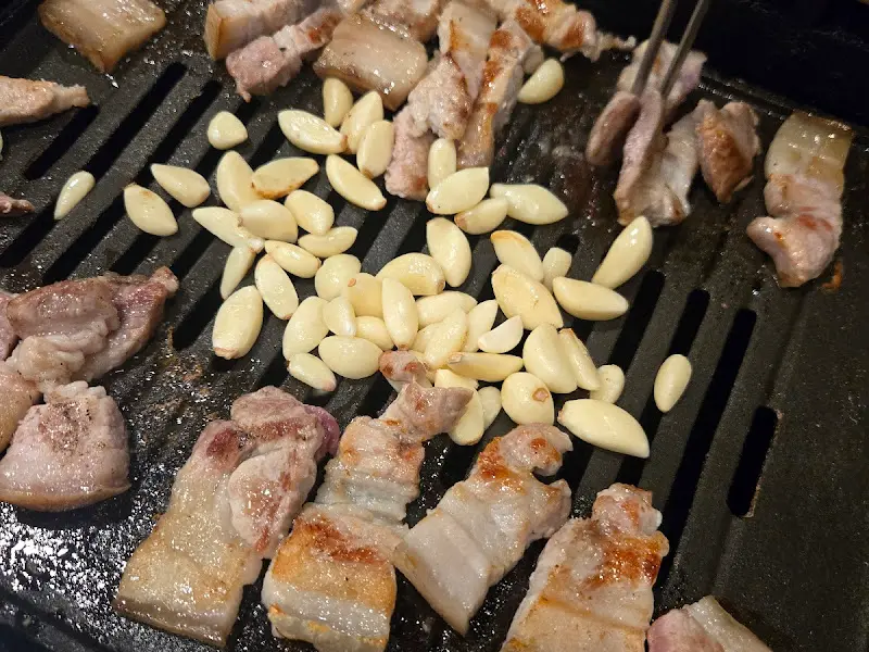 불판 위에서 익어가는 생고기와 마늘