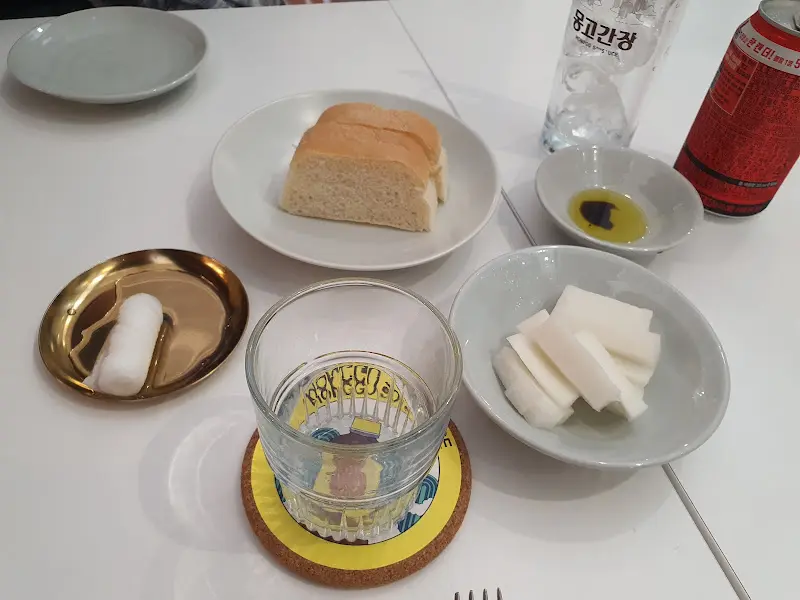 테이블 세팅: 식전빵과 올리브 오일, 물 등이 정갈하게 놓여 있다.