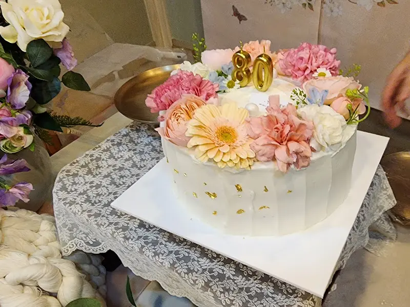 꽃 장식으로 화려하게 꾸며진 팔순 기념 케이크