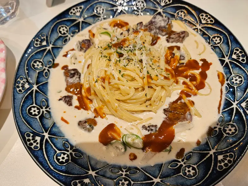 크림 파스타 위에 올려진 고기