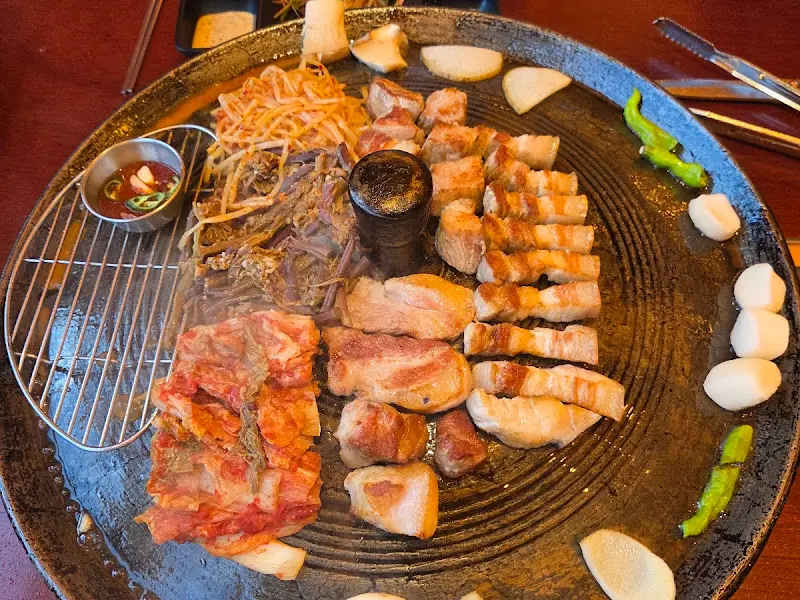 솥뚜껑 가운데 놓인 작은 종지에 담긴 양념 소스