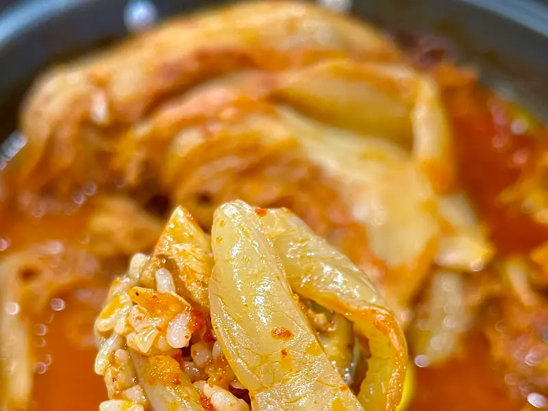 숟가락 위에 올려진 묵은지와 밥