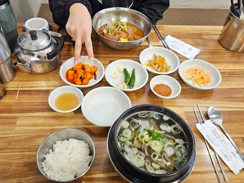 테이블 위에 놓인 갈비탕과 다양한 밑반찬