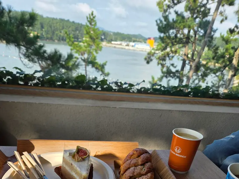 테이블 위에 놓인 음료와 케이크, 그리고 창밖으로 보이는 진도대교