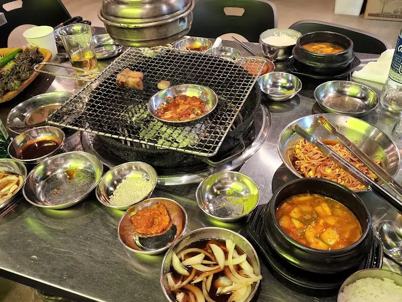 불판 위의 삼겹살과 곁들임 메뉴