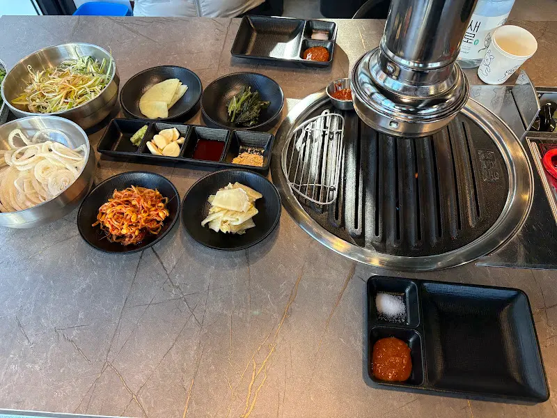 테이블 가득 차려진 밑반찬과 고기