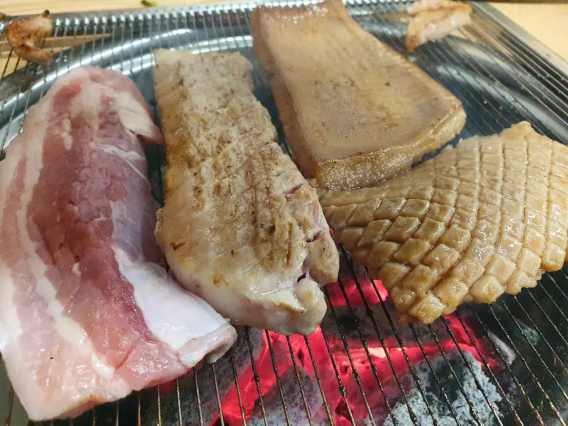 숯불 위에서 익어가는 삼겹살과 껍데기