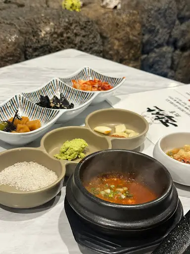 다양한 밑반찬들이 정갈하게 차려져 있어요. 김장아찌, 멜젓, 와사비 등이 눈에 띄네요.