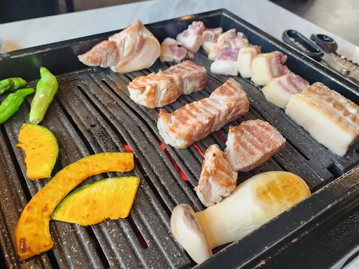 다양한 부위의 흑돼지와 버섯, 옥수수, 파프리카 등이 불판에서 익어가고 있어요