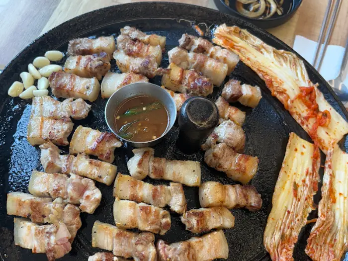 솥뚜껑 삼겹살과 함께 구워진 김치, 마늘, 콩나물