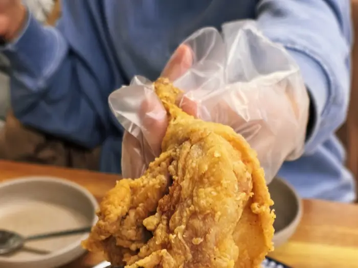 손으로 닭다리 튀김을 들고 있는 모습