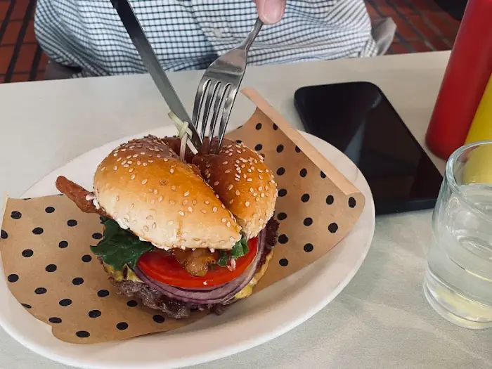 포크와 나이프로 버거를 자르는 모습