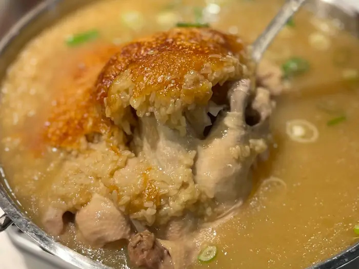 백숙의 닭고기와 누룽지를 함께 떠내는 모습