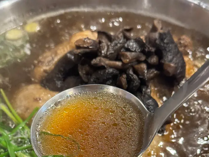 국자로 백숙 국물을 뜨는 모습