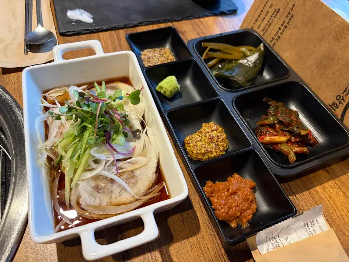 다양한 부위의 소고기, 신선한 채소, 마늘, 버섯 등이 담긴 철판