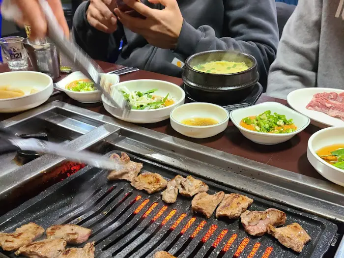 테이블에 차려진 여러 가지 반찬과 갓 구워진 고기