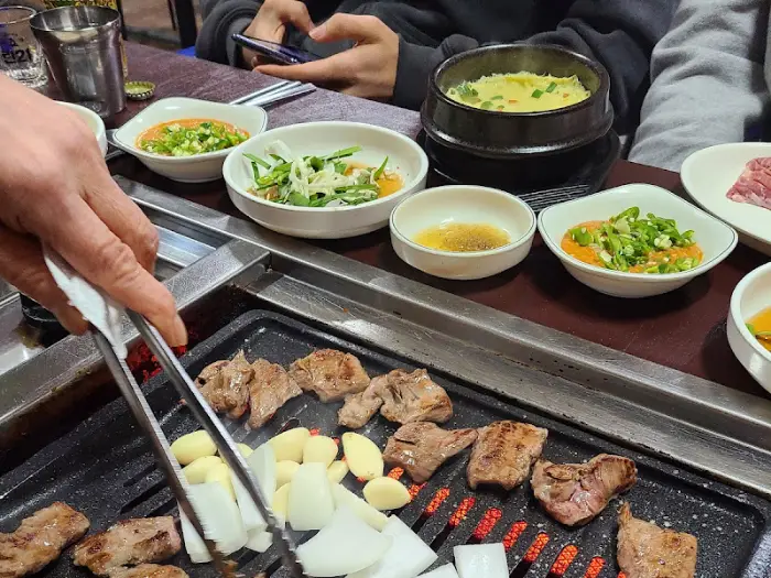 불판 위에서 구워지는 고기와 주변의 테이블 모습