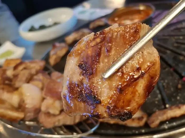 집게로 집은 고기 한점