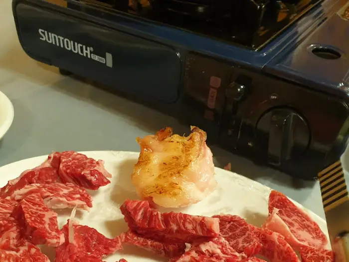 불판 위에 구워지고 있는 두툼한 등심 고기