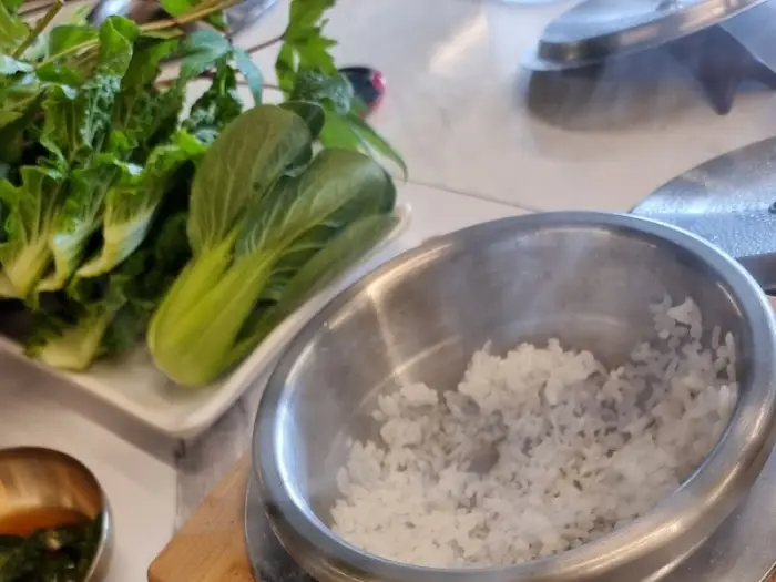 김이 모락모락 나는 솥밥과 신선한 쌈 채소
