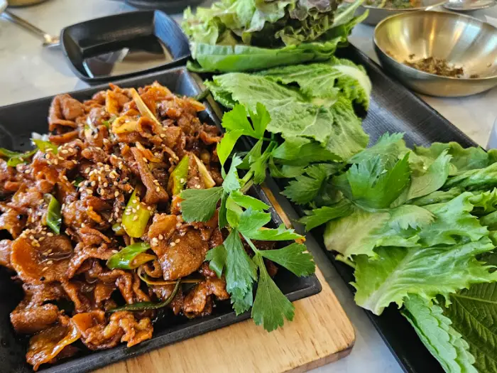 윤기가 흐르는 제육볶음과 신선한 쌈 채소