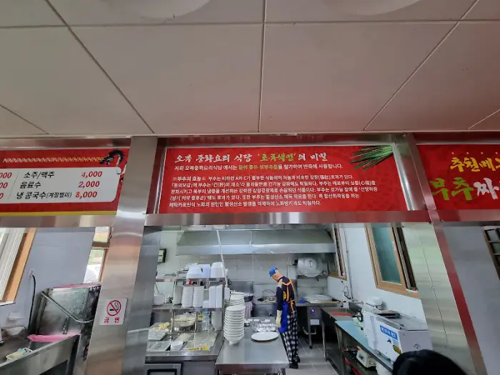 짜장면 위로 굵직하게 썰린 감자, 양파 등의 건더기가 보이는 클로즈업 샷