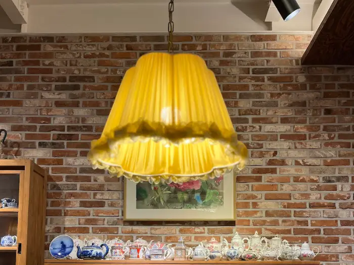 벽난로 옆에 놓인 앤티크한 삼각주전자와 찻잔 컬렉션