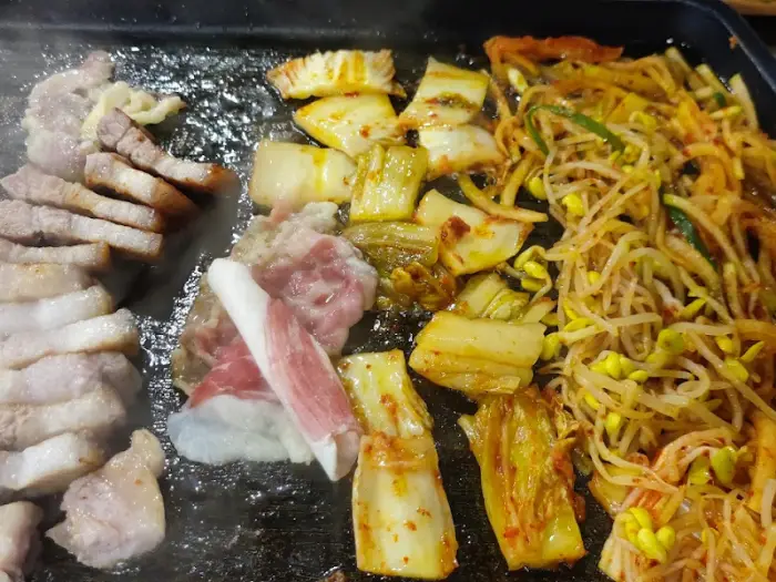 불판 위에서 구워지는 고기와 반찬들