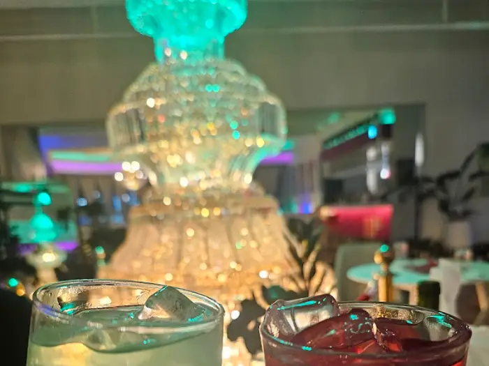 화려한 샹들리에를 배경으로 놓인 칵테일 잔