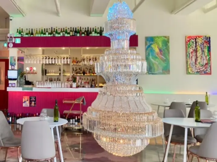 화려한 샹들리에와 와인 병이 놓인 테이블