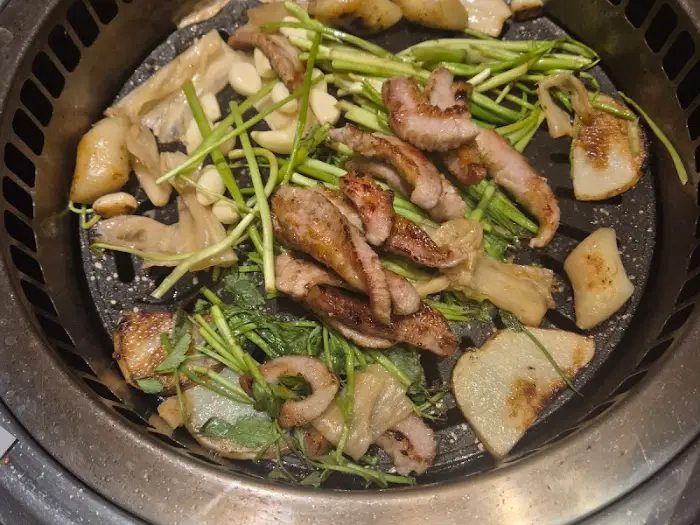 잘 익은 항정살과 곁들임 채소, 마늘 등이 불판 위에서 익어가고 있다.