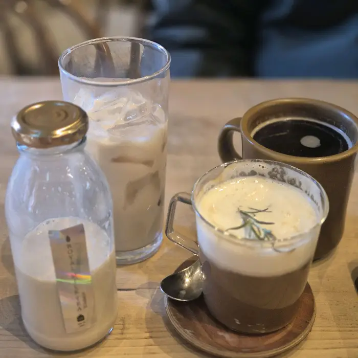 다양한 음료가 담긴 컵과 병. 병에는 라벨이 붙어있다.