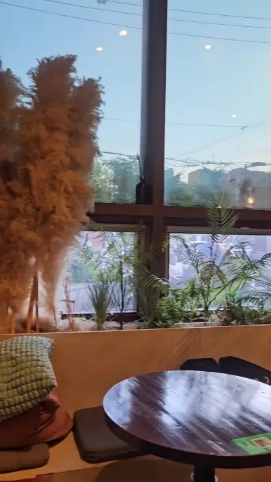 창밖 풍경을 비추는 모습. 푸른 하늘과 건물이 보인다.