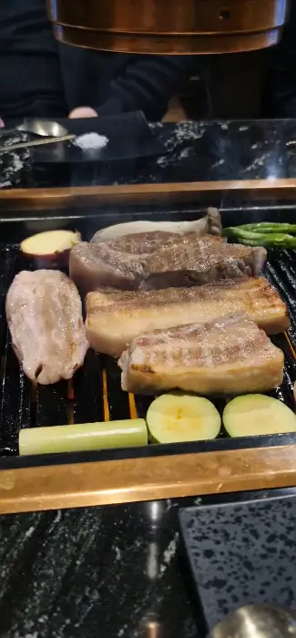 숯불 위에서 익어가는 얼룩돼지고기와 채소