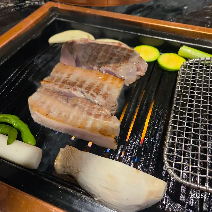 불판 위에서 구워지고 있는 돼지고기, 버섯, 애호박, 단호박