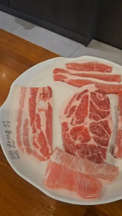 신선한 돼지고기 부위들이 담긴 접시