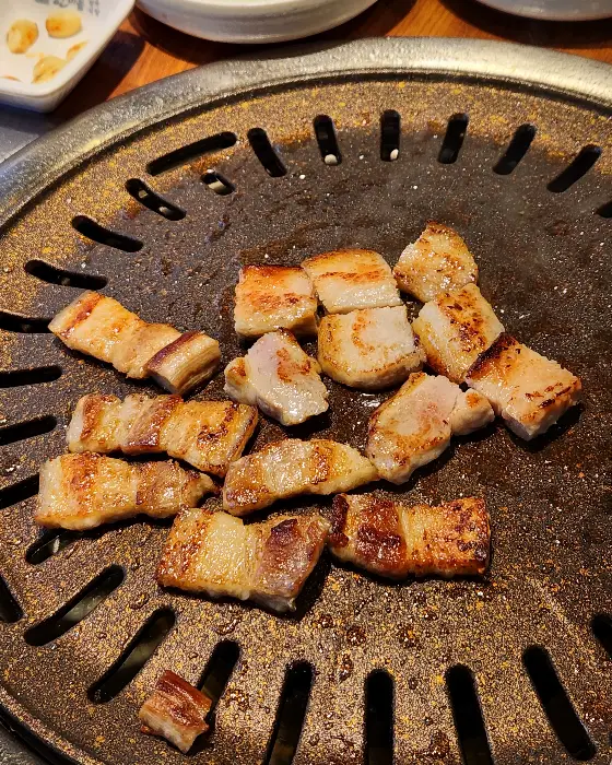 불판 위에서 노릇하게 구워지고 있는 삼겹살