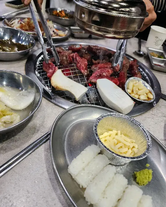 테이블 가득 차려진 음식과 숯불구이 풍경