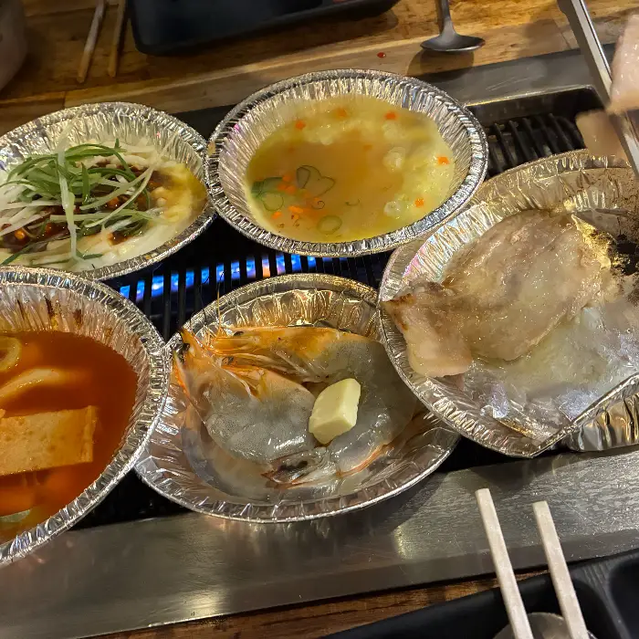 모둠 조개구이, 활어회, 대하구이, 삼겹살 등이 차려진 한상차림