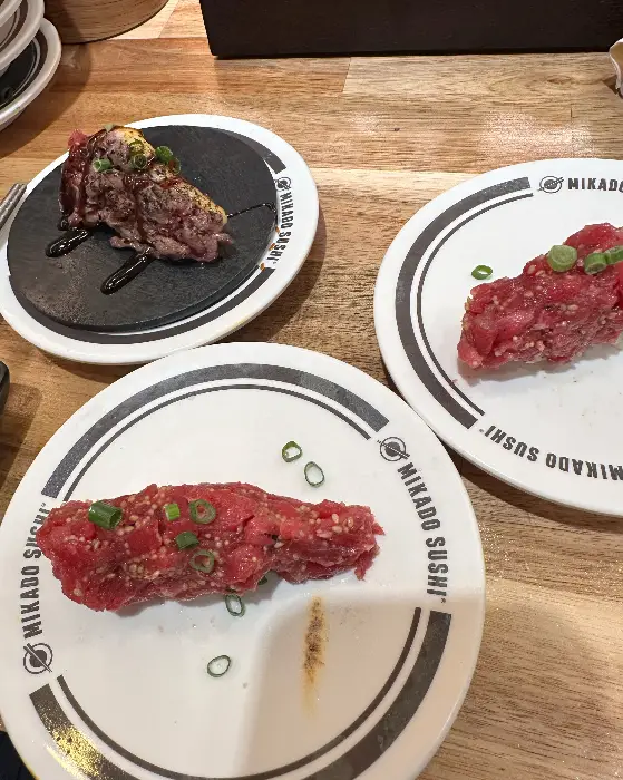 붉은 빛깔의 신선한 육회 초밥과 스테이크 초밥이 접시에 담겨 있다.