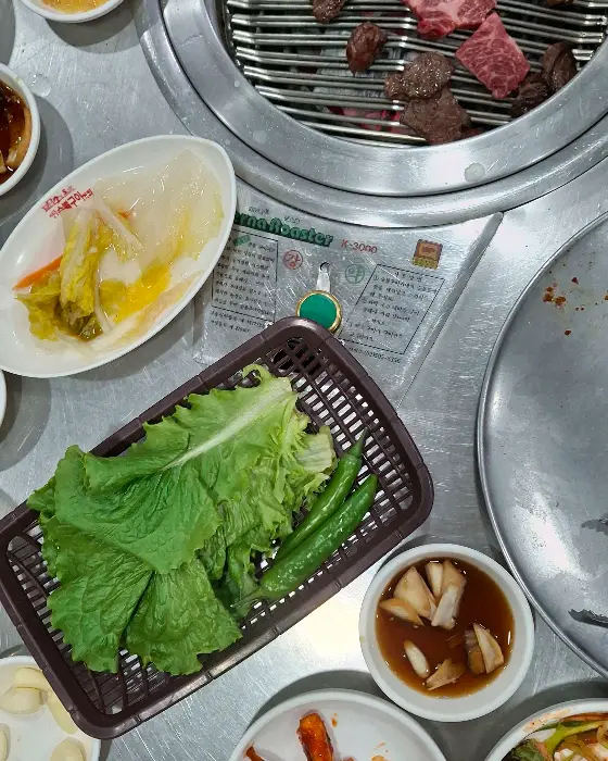 불판 위에 겹겹이 쌓여 익어가고 있는 고기들