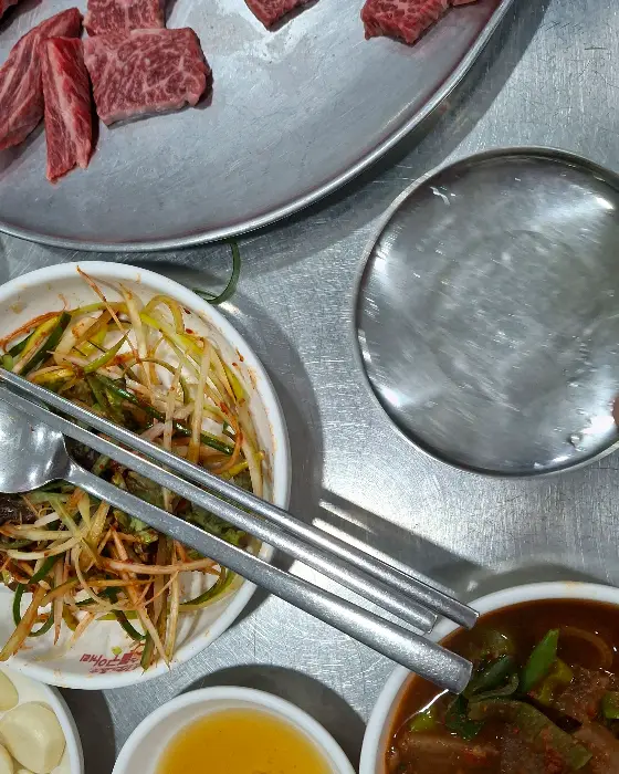 한쪽에는 샐러드가, 다른 한쪽에는 밥과 젓가락이 놓여 있습니다.